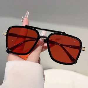 Black double-bridge aviator sunglasses with red translucent lenses and gold textures