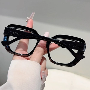 Detail of glossy black oversized cat-eye frames with stylish geometric thick rims