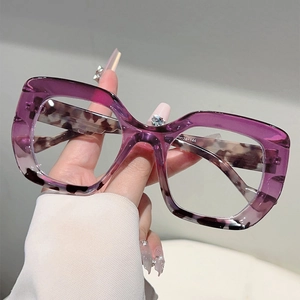 Cat eye glasses with purple upper and leopard print lower frames in a close-up shot
