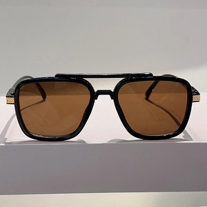 Detail of oversized sunglasses with double bridge and golden textured metal hinges