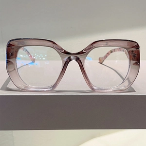 Detail view of large purple-grey cat-eye glasses with intricate floral inner temple design