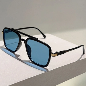 Detailed close-up of double-bridge sunglasses featuring gold textured metal hinges
