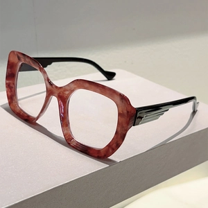 Detail of red-brown marble cat-eye glasses frame with decorative wing-shaped temples