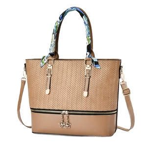 Minimalist khaki woven tote bag with silk scarf handle and floral charm accents