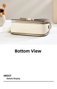 Detail view of the beige saddle bag bottom with black edge finish and gold metal accents