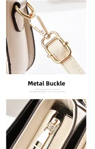 Detail of premium gold-toned metal buckles and smooth zipper on a beige saddle bag