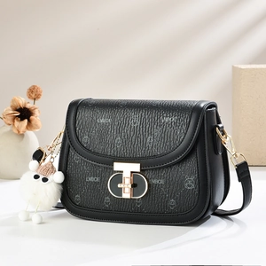 Elegant black saddle bag with textured leather and gold clasp in minimalist setting
