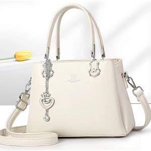 Close-up of beige fashion handbag featuring David Jones Paris logo and metal heart charm