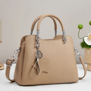 Beige litchi leather tote bag with silver metal accents and a star charm detail