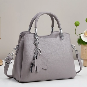Chic grey macaron tote bag in pebble leather with star pendant and crossbody strap