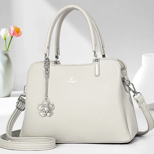 Detailed macro view of white lychee pattern leather bag with floral charm and silver logo