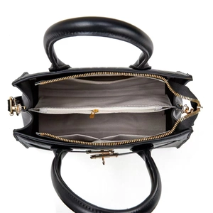 Top view of black leather handbag interior with gray herringbone lining and compartments