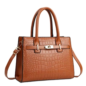 Brown crocodile textured top handle bag with gold hardware and shoulder strap on white base