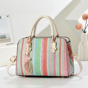 Detail of colorful rainbow woven handbag with gold leaf charm and beige handles