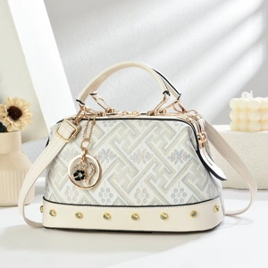 Detail of white crossbody bag featuring floral texture prints and golden rivet accents