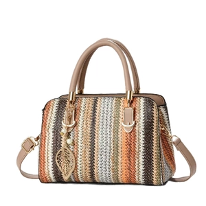 Bohemian woven striped handbag with tan leather straps and gold leaf pendant charm