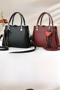 Detail of lychee pattern leather tote bag with silver buckle and red heart charm