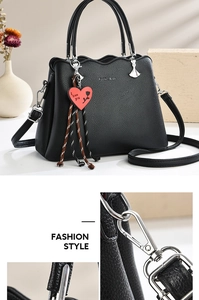 Detail of black pebbled leather handbag with red heart charm and silver hardware