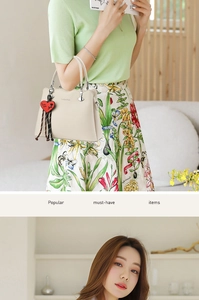Detail of lychee pattern leather tote bag with a Love You heart charm for women