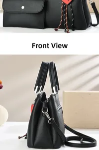 Detail of black litchi texture leather handbag set with silver hardware and shoulder strap