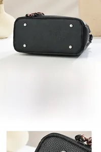 Detail view of the black lychee texture bag base with four protective silver metal studs