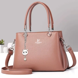 Detailed view of mauve leather tote with silver brand logo and floral metal hardware