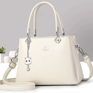Close-up of cream leather shoulder bag with DAVID JONES logo and panda charm detail