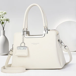 Detail of white litchi pattern leather handbag with silver hardware and logo