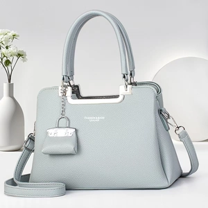 Detail of light blue lychee grain leather handbag with silver hardware and mini pouch