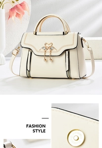 Detail view of cream crossbody bag featuring golden swan buckle and pearl charm accent
