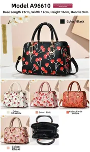 Detail view of cherry print crossbody bag showing interior pockets and 22x12x16cm dimensions