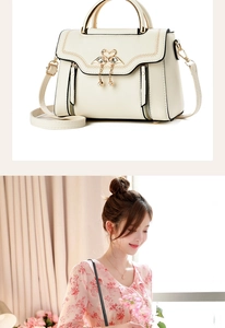 Detail of a creamy white handbag featuring a gold swan clasp and elegant pearl tassel charm
