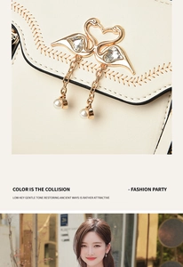 Detail of cream crossbody bag featuring a golden swan buckle with rhinestones and pearls