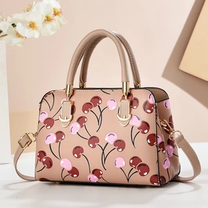 Minimalist crossbody bag in nude pink with red cherry pattern and golden hardware
