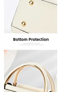 Detail of beige leather handbag with gold metal ring handle and bottom protective studs