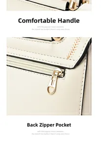 Detail of cream crossbody bag featuring a golden heart zipper and sturdy top handle