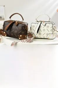 Detail view of two patterned Boston bags with elegant wide geometric fabric shoulder straps