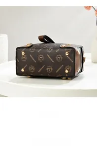 Detailed bottom view of brown monogram Boston bag with gold protective metal feet