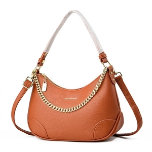 Détail du sac croissant caramel en cuir grainé avec chaîne décorative dorée élégante