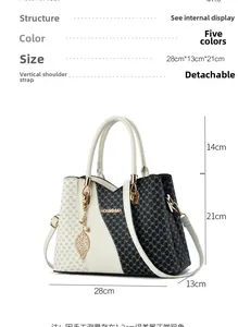Detailed view of the printed handbag with dimensions 28cm x 13cm x 21cm and leaf charm