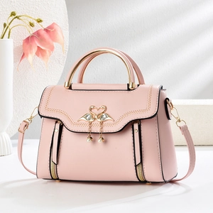 Pink PU leather crossbody bag with swan heart clasp and golden circular handles