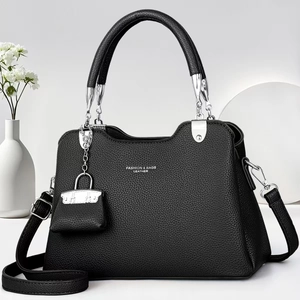 Détail du sac à main en cuir grainé noir avec ferrures argentées et mini pendentif