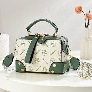 Boston style crossbody bag with vintage green trim and patterned woven shoulder strap