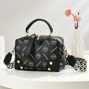 Black leather Boston handbag with geometric woven strap and gold-tone hardware