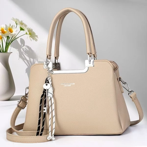 Elegant beige pebbled leather handbag with silver hardware and adjustable shoulder strap