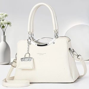 Detailed macro of white litchi pattern leather bag with silver metallic handle
