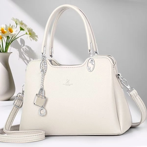 Detail of off-white lychee leather handbag with silver lock charm and chain