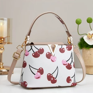 Elegant white bucket bag with cherry print, brown handle, and gold V-shaped metal buckle
