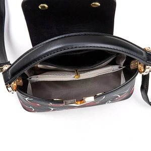 Detail view of printed handbag interior with zip compartments and gray textured lining