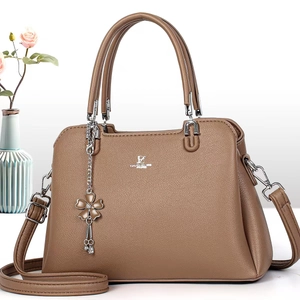 Brown faux leather trapezoid handbag with dual handles and metal flower charm decoration